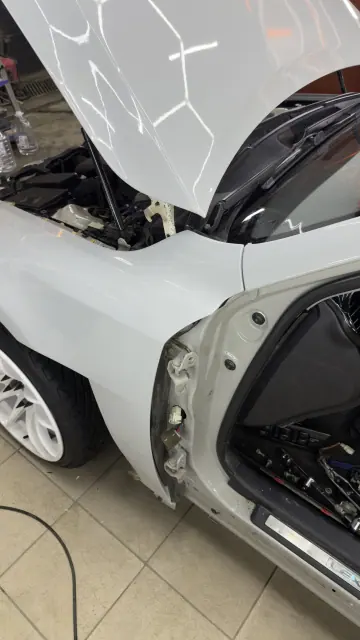 Белый Volkswagen Passat со снятым бампером — разбор кузова перед сменой цвета
